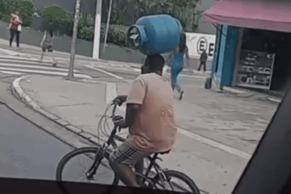 Cena inusitada mostra homem pedalando com botijão equilibrado na cabeça