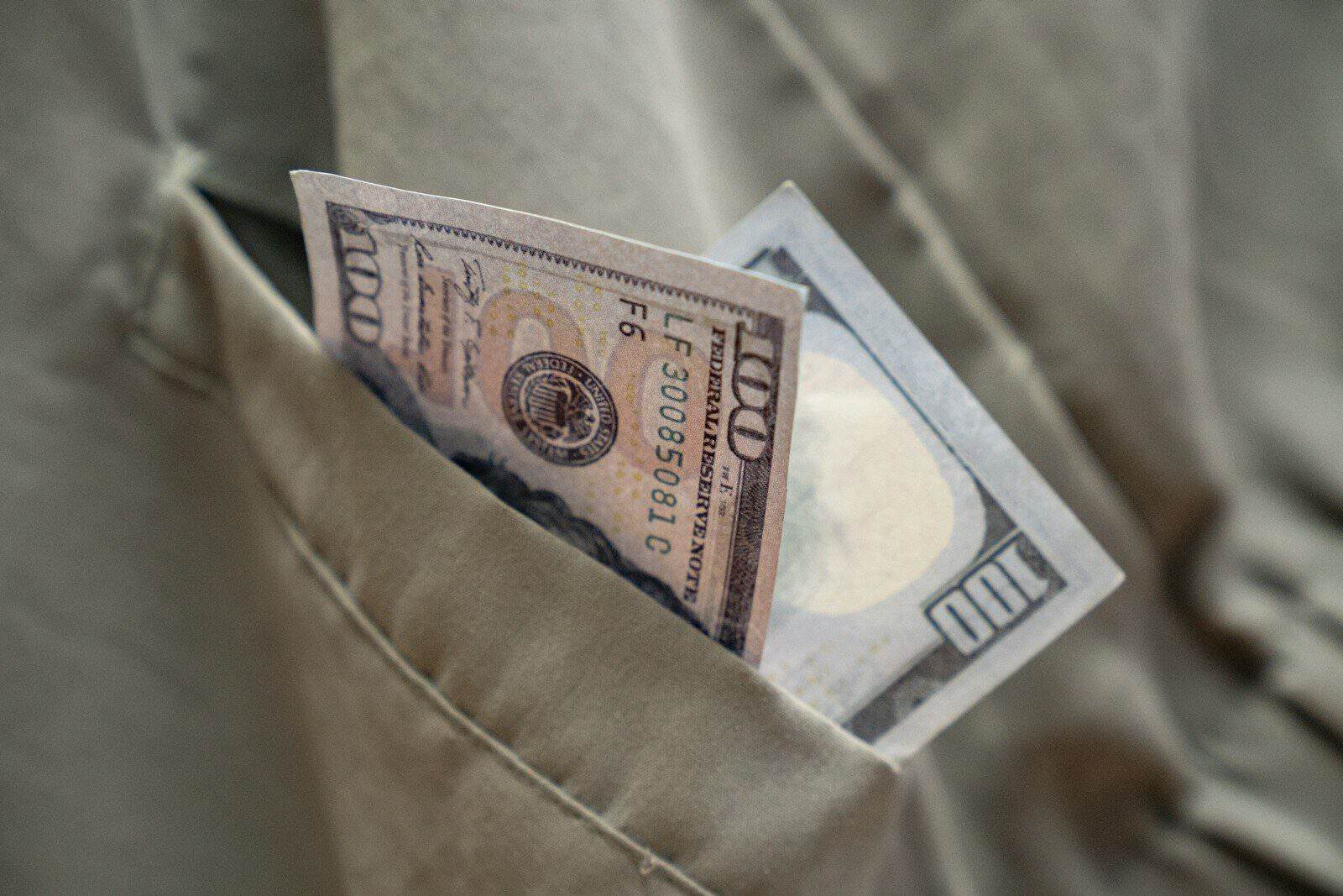 a dollar bill sticking out of a pocket