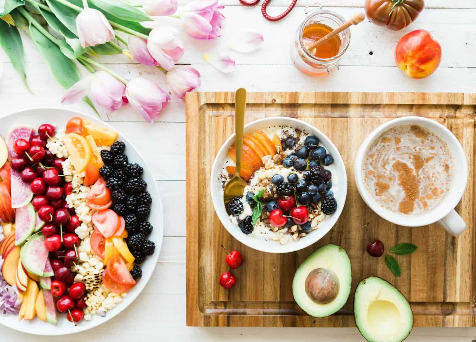A bowl of yogurt with fruit and a cup of coffee for breakfast