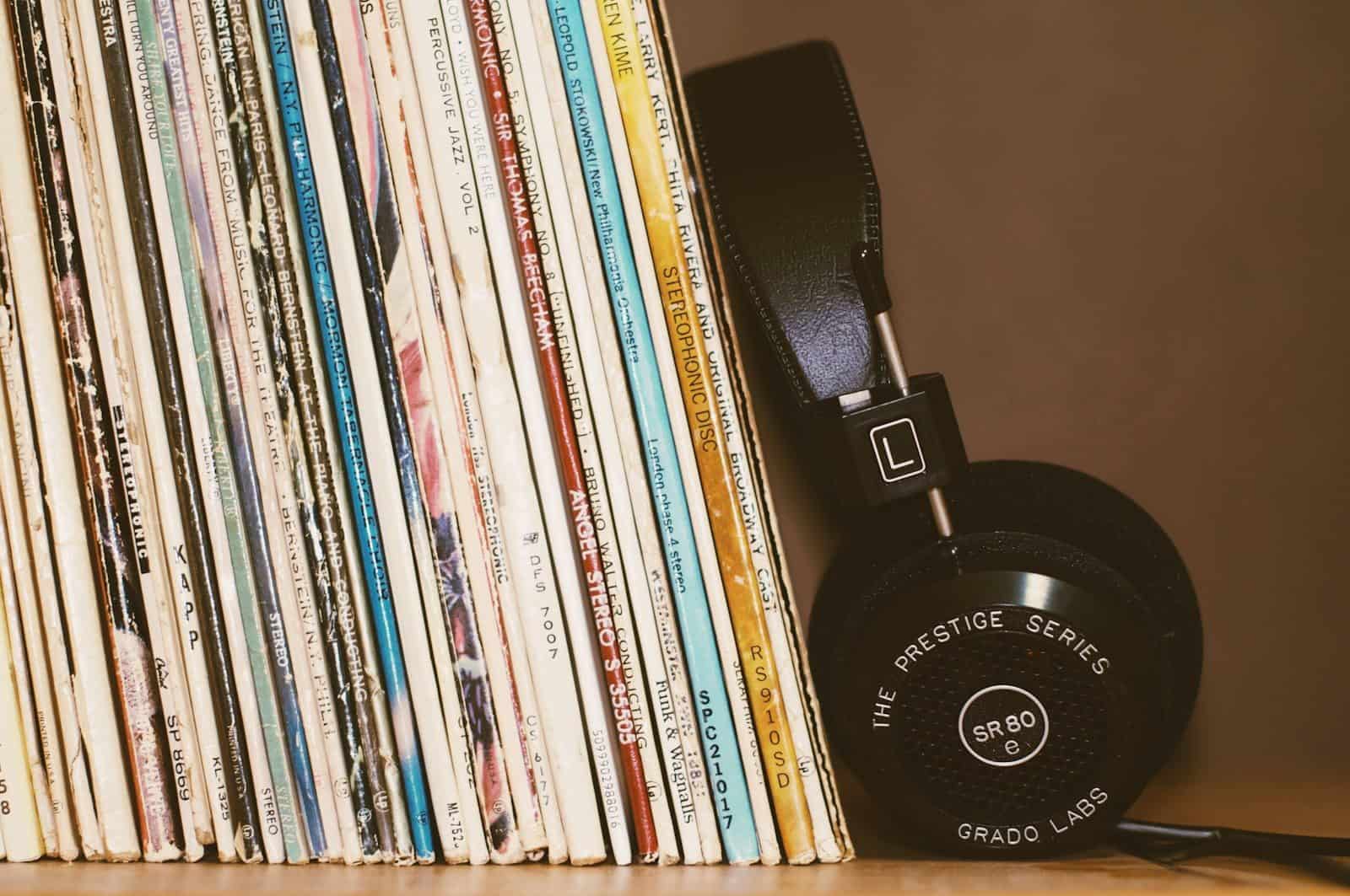 Black headphones resting against a row of vintage vinyl record albums