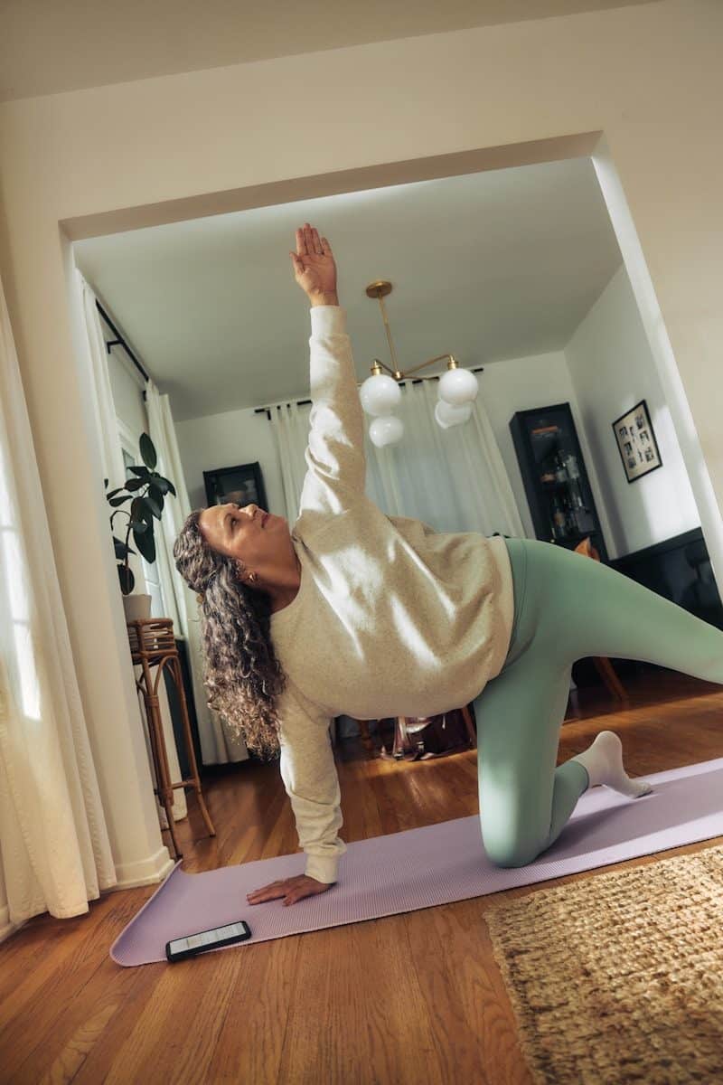 A woman does a yoga pose on a mat