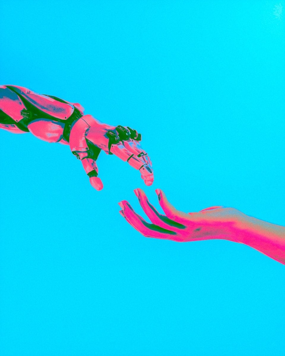 robot and human hands reaching toward each other