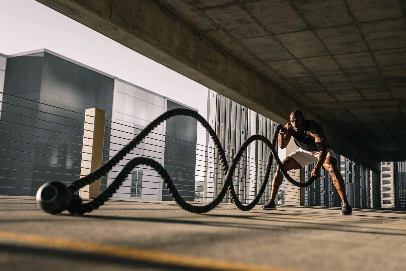 man exercising with battle ropes outdoors