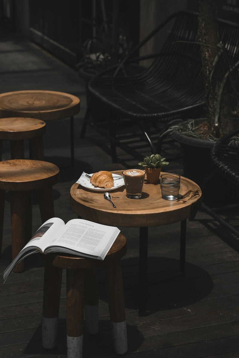 latte croissant and book on cafe table