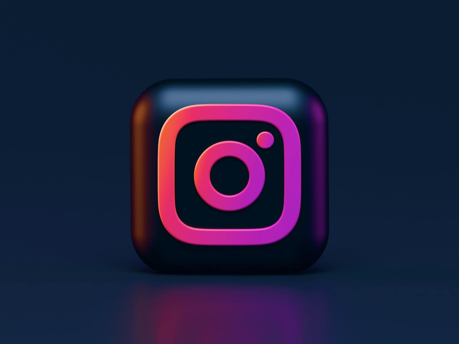 A three-dimensional Instagram logo icon with pink and orange gradient lighting