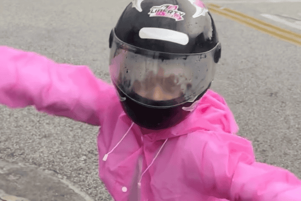 Pai improvisa e coloca filha no baú da moto para protegê-la da chuva