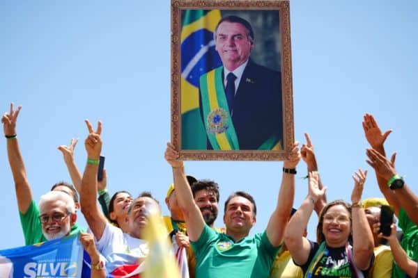 Flávio exibe quadro de Bolsonaro com faixa presidencial e provoca TRE: “Vem tomar aqui”