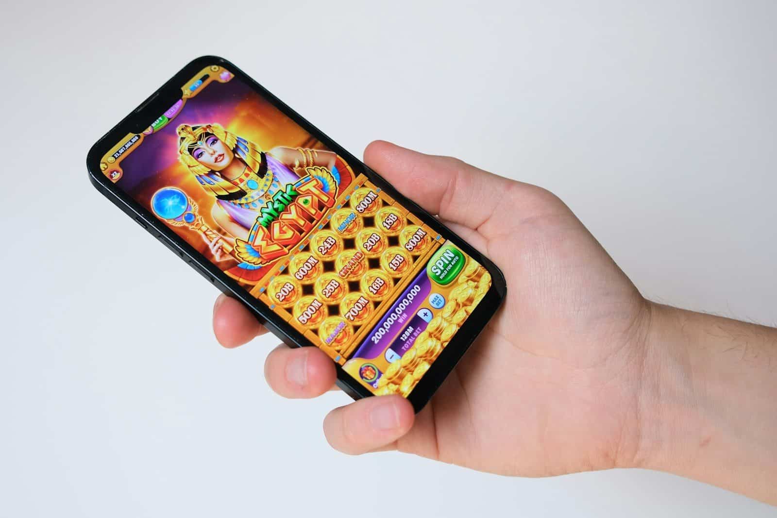 A hand holds a phone with an egyptian-themed game
