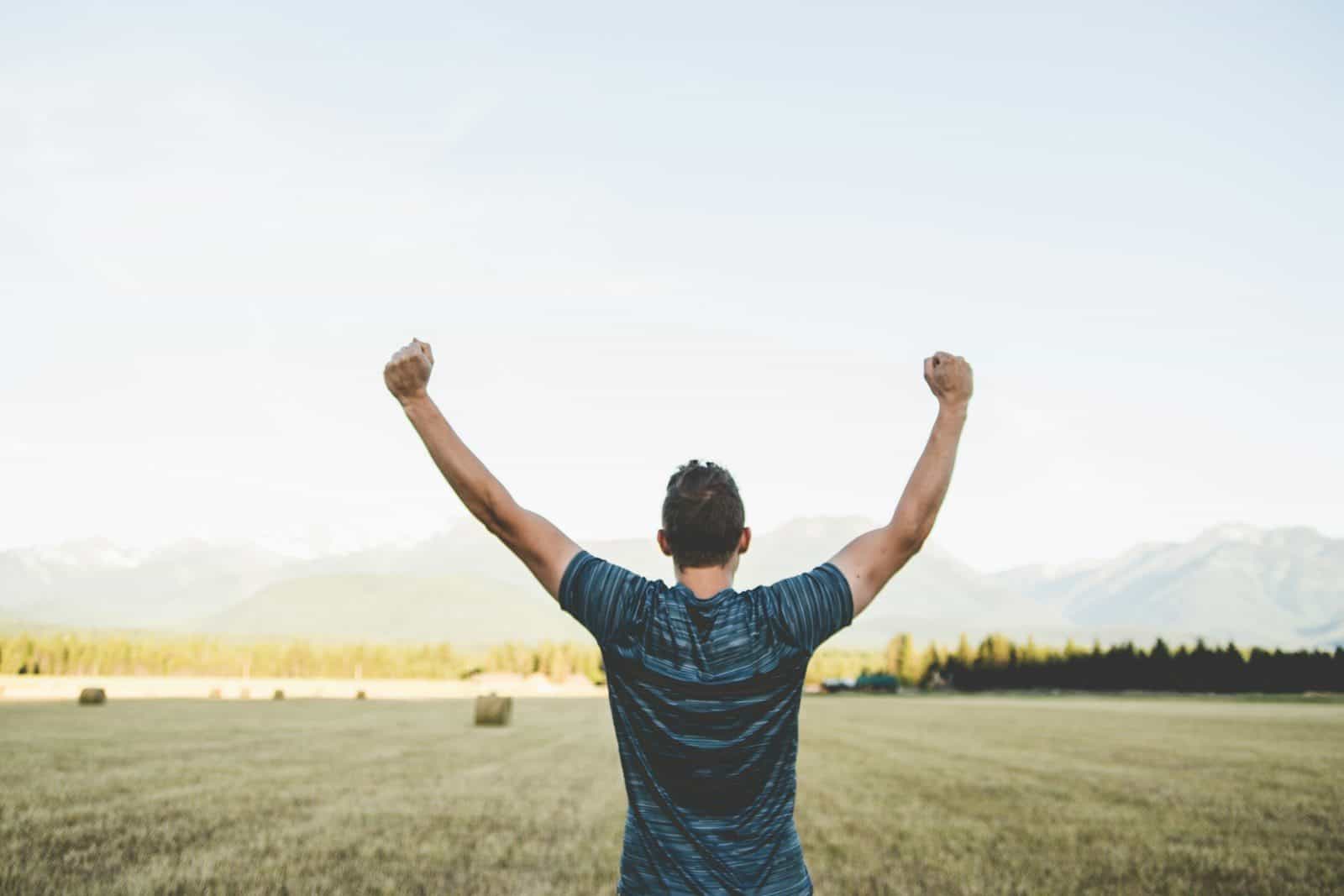 man reaching hands up high taken at daytime
