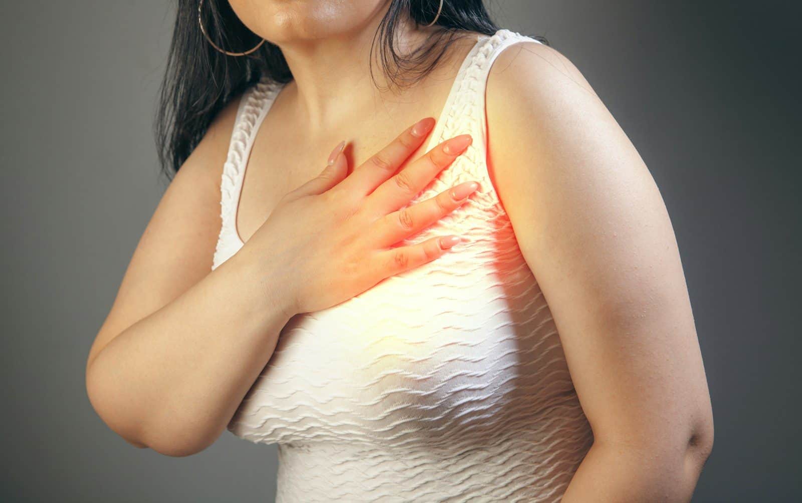 Woman holding her chest with a hand
