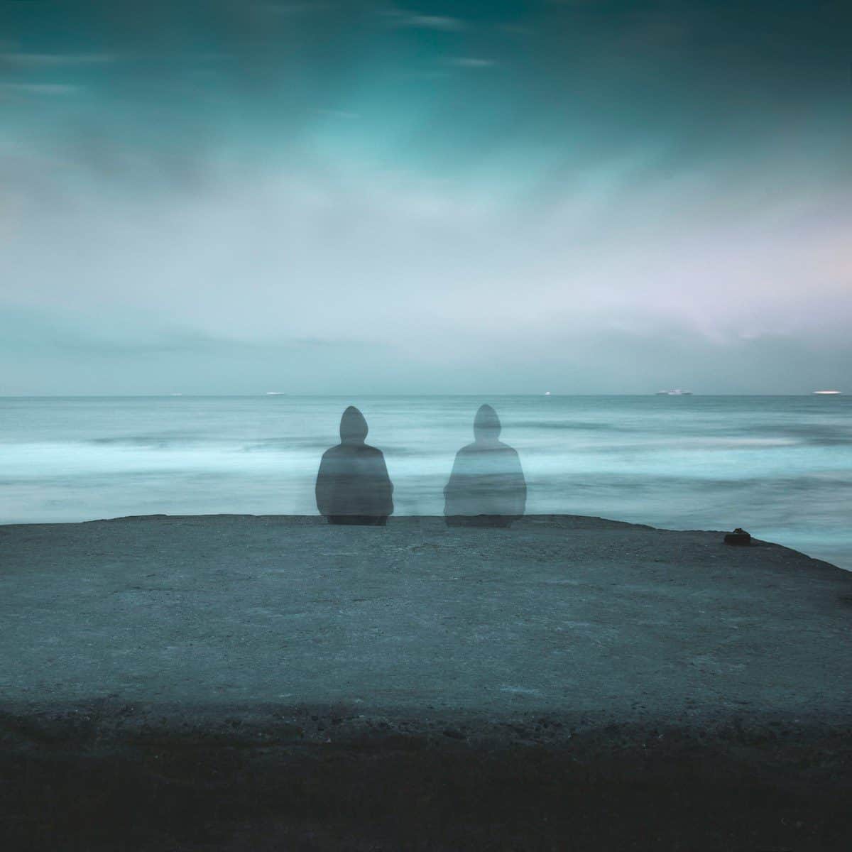 3 white and gray stone on black sand near body of water during daytime