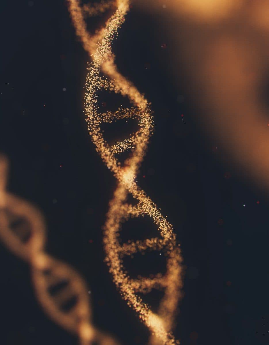 A glowing golden DNA double helix structure composed of tiny particles against dark space