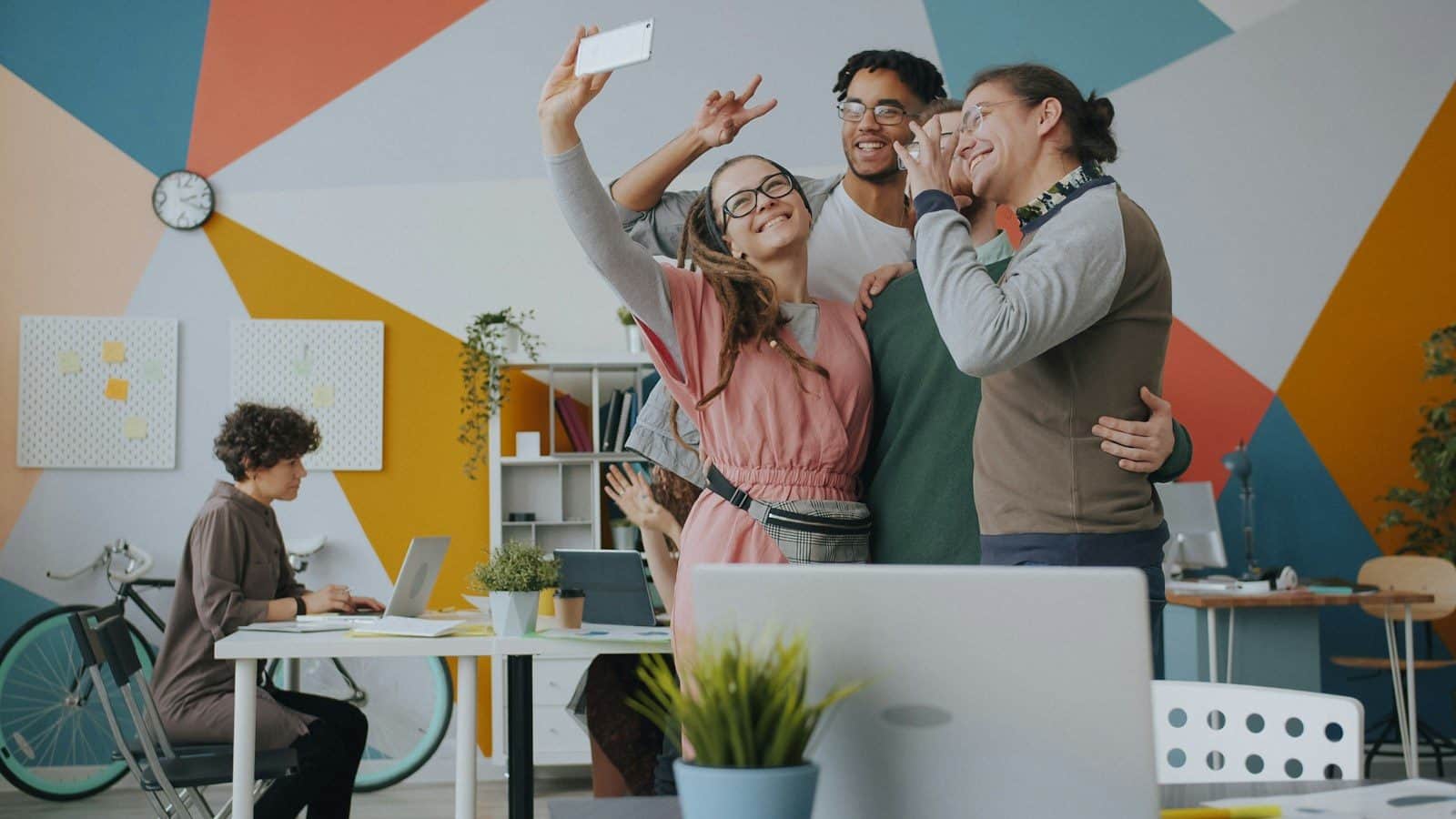A group of people taking a selfie in a colorful modern office