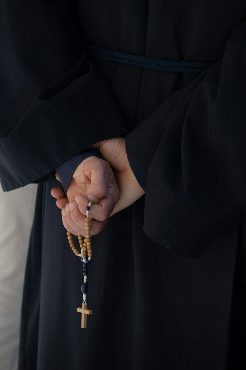 a person holding a rosary in their hands