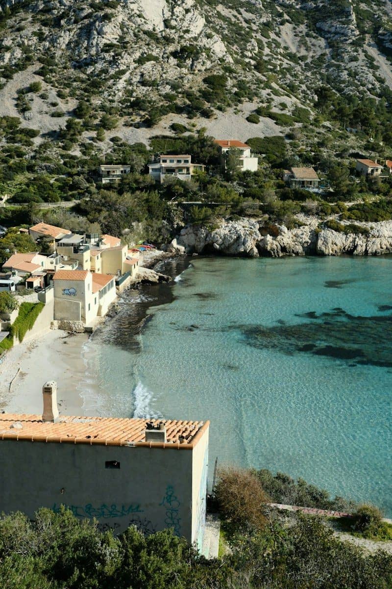 Coastal village with clear blue water and rocky hills