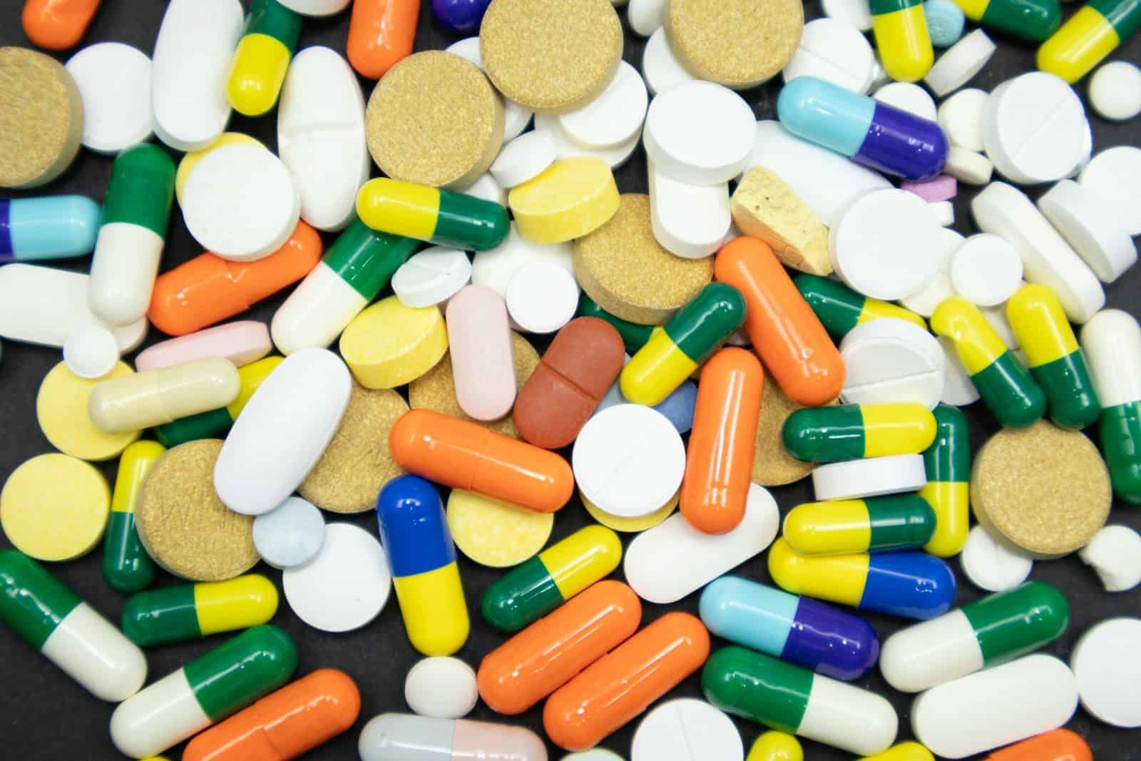 Assortment of colorful pills and capsules scattered randomly