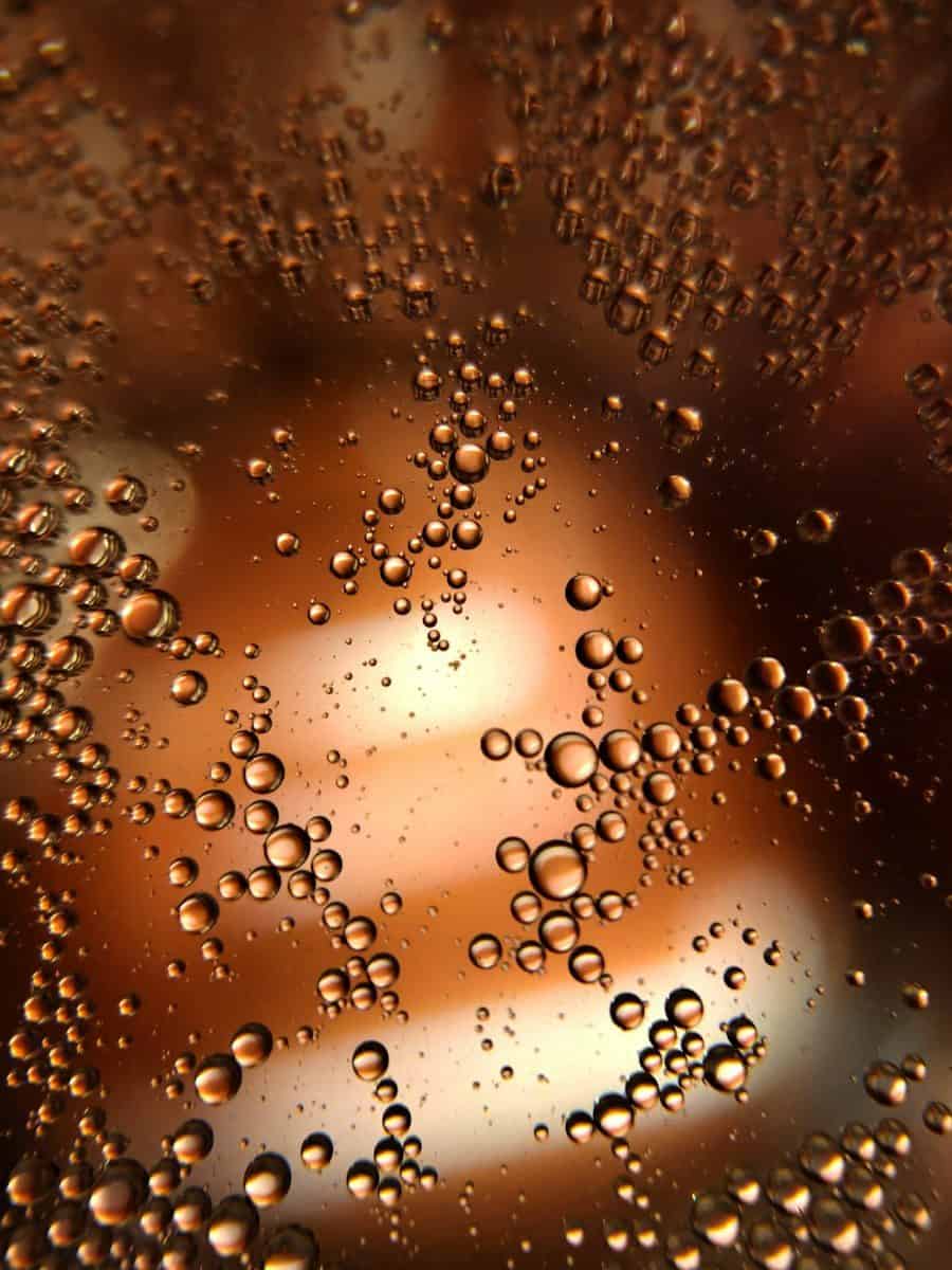 Numerous small brown bubbles against a blurred warm background