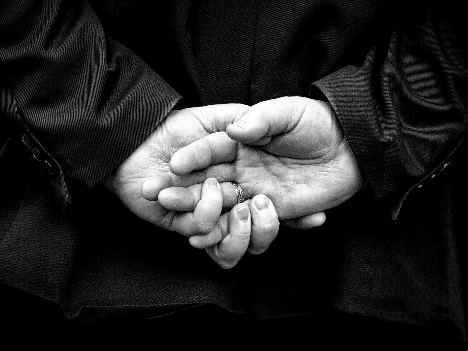 Hands clasped behind a person's back
