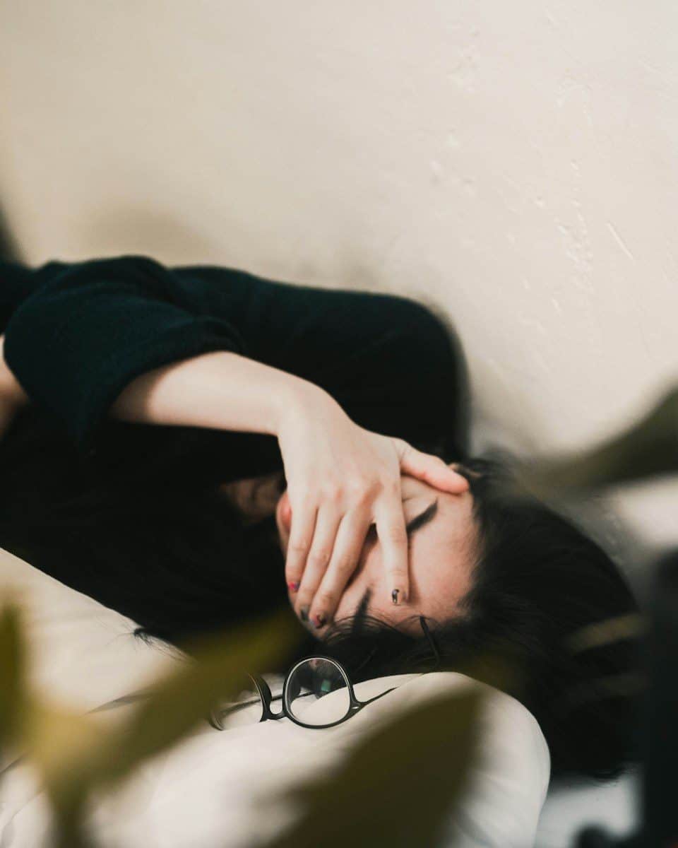 woman in black long sleeve shirt covering her face